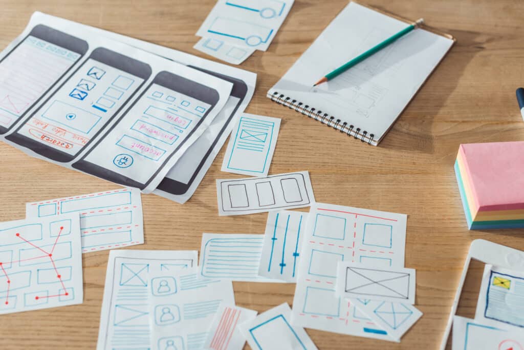 Selective focus of mobile website sketches and layouts on wooden table